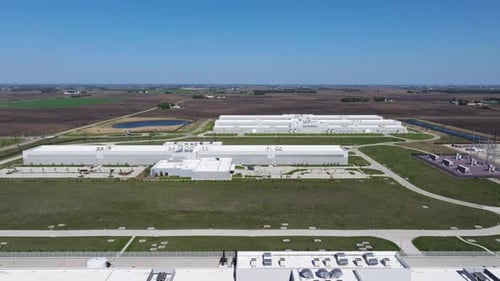 Backward drone shot reveals full scale of a hyperscale data center campus surrounded by