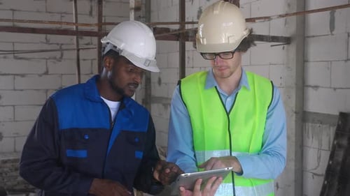 Teamarchitekt zwei junger Mann diskutieren und suchen digitales Tablet für Inspektionsbaustelle.