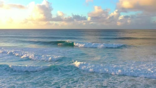 Surfers Ride Waves in Tropical Blue Ocean at Sunset, Aerial Drone Above