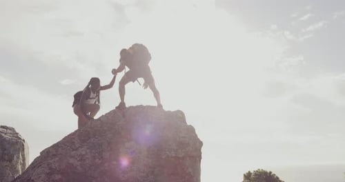Couple Reaching Mountain Peak Helping Each Other