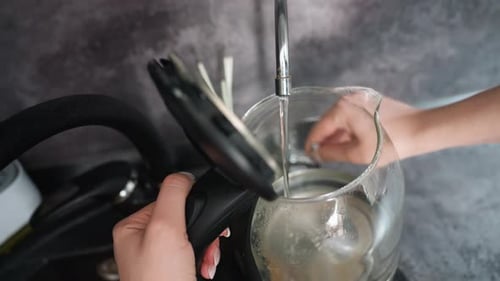 Person Controls Stream Of Boiling Water Into Clear Teapot Hands Carefully Pour Steaming Hot Water