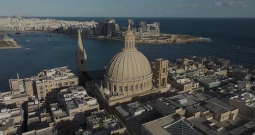 Aerial view of cathedral and cityscape by Mediterranean Sea, Malta.
