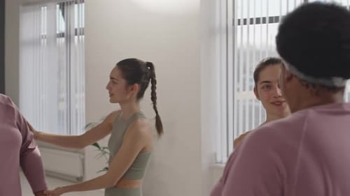 Woman Receives Workout Assistance Holding Dumbbells