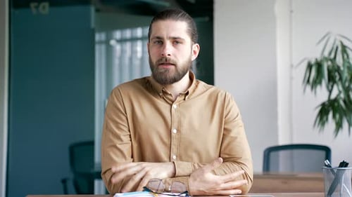 Webcam view. Businessman watching video call training looking at camera while sitting at workplace