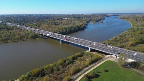 Aerial view of road bridge highway across the river in city area. Lorry is driving on the bridge. Sk