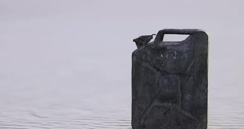 Schwarzer Behälter ruht auf der Wasseroberfläche in natürlicher Umgebung bei Sonnenuntergang