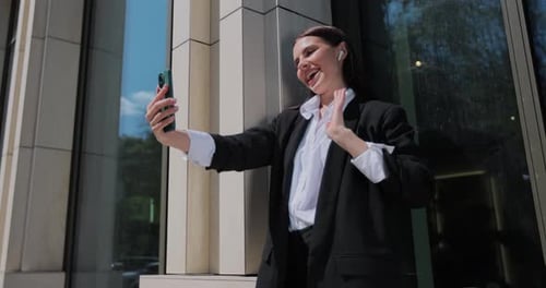 Woman with Smile Greeting on Smartphone for Social Media or Online Chat on City Street Modern