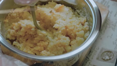Le chef broie la purée de pommes de terre, mélange la purée avec les jaunes d'œufs.