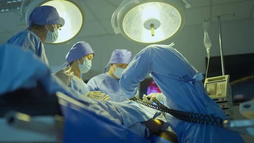 Doctor use defibrillator to help patient lie on bed in operation room in hospital and team support