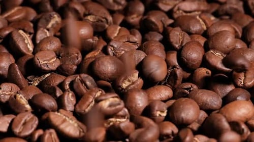 Wunderschöne Zeitlupenaufnahme fallender gerösteter Kaffeebohnen.