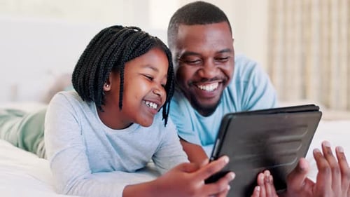 Happy Child and Adult Use Tablet in Bed