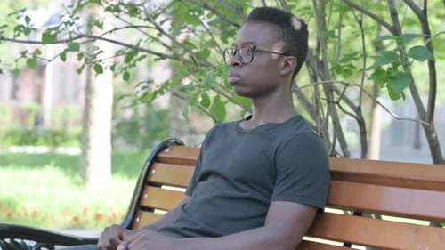 Man Relaxing on Bench in Park