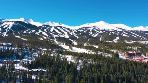 Snow-Covered Ski Trails Across Mountain Slopes and Snowy Peaks. Beautiful Aerial Drone View of Cold
