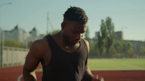 Muscular Man Running on Track Field