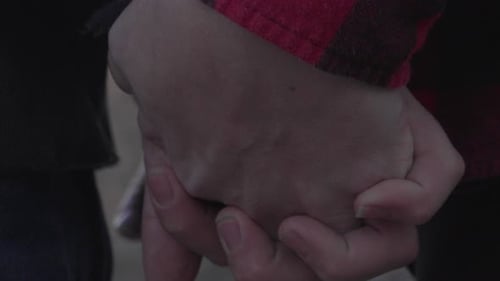 close up shot of a couple holding hands as the mans thumb caresses the woman's hand