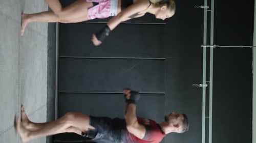 Man and Woman Doing Pushups in Gym
