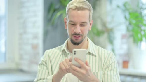 Excited Man Reacting to Good News on Phone