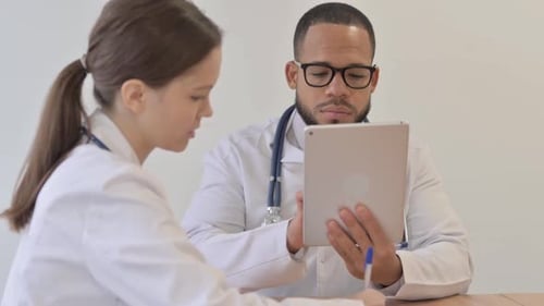 Multi Ethnic Doctors Working while Sitting in Hospital