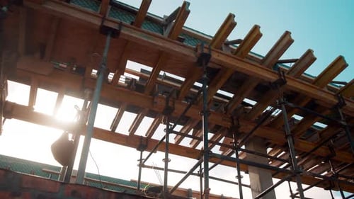 Abajo, madera y vigas con andamios para la construcción, la estructura del edificio y el soporte de la azotea
