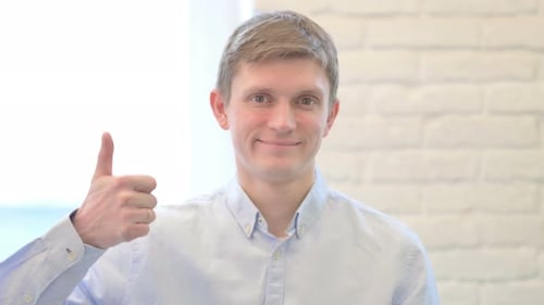 Adult Man Giving Thumbs Up in Studio Setting