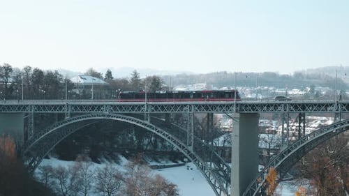 Red tram passing over a bridge and a sunny winter day in Bern, Switzerland.