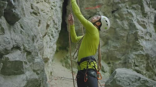 Man Prepares to Rock Climb in Mountainous Area