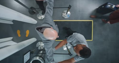 Security Agent Patting Down Man at Airport