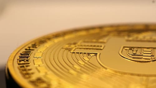 rotating physical gold coin of bitcoin, close up shot