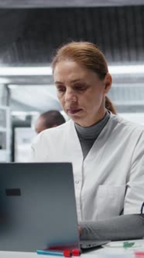 Woman working on laptop with headache in lab