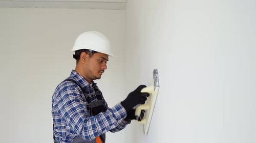 Construction Worker Applying Plaster Indoors