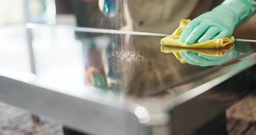 Adult Cleaning Glass Table Surface with Cloth