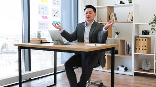Confident Businessman Meditating at Desk in Modern Office Setting