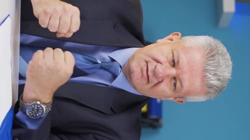 Businessman Sitting and Speaking at a Desk