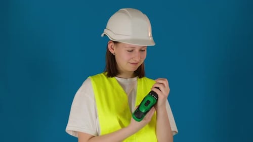 Lady Pulls Out and Inserts Drill Bit in Drill on Blue