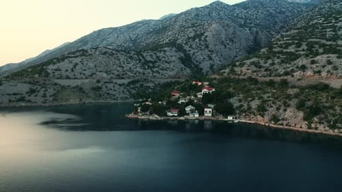 Coastal Village Among Rugged Mountains Surrounded By Sea