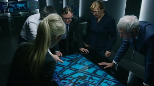 Team Analyzing Digital Map Display in Dark Control Room