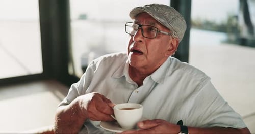 Senior Man Drinking Coffee in Urban Cafe