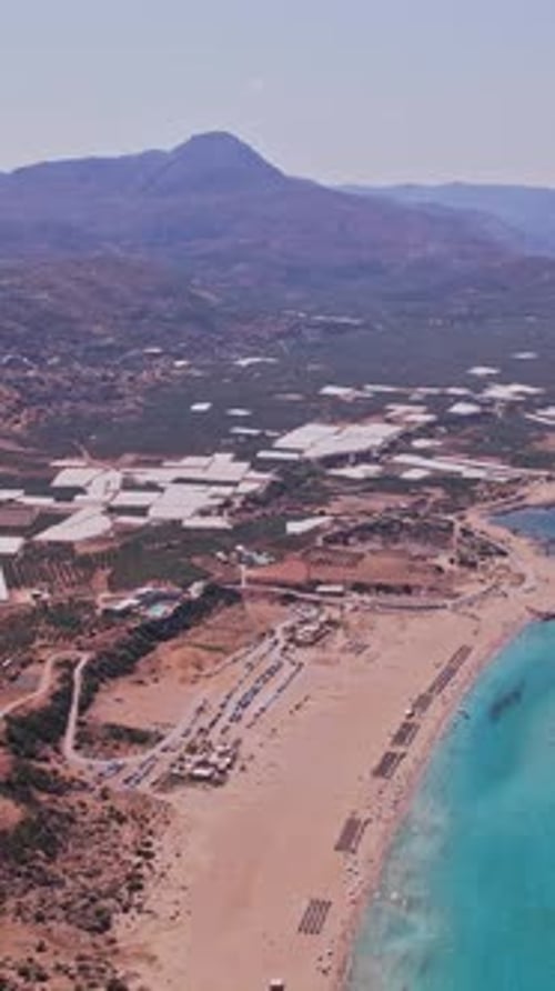 Aerial view of a serene coastline with crystal blue waters and mountains