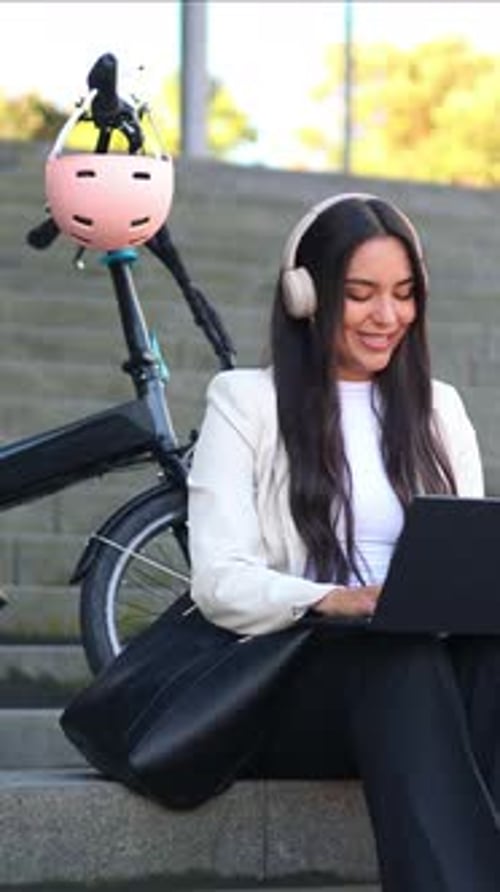 vertikale Professionelle Geschäftsfrau mit Faltrad, die am Laptop arbeitet