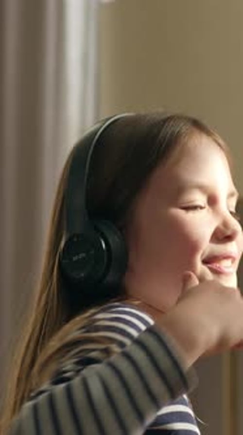 Caucasian Little Girl Child Kid Listening Music in Modern Wireless Headphones Dancing Moving Hands