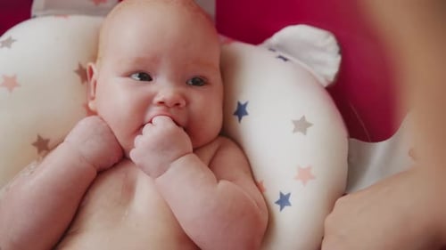 Mother Bathes Her Baby in Pink Bathtub Top View
