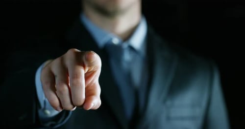 Executive in Suit Points Finger at the Viewer