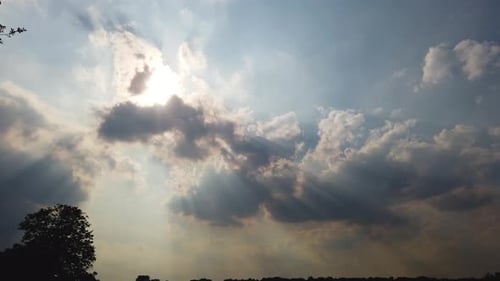 Cumulus clouds covering the Sun causing strong shadows and light rays, Tyndall Effect.