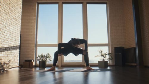 Determined Man Holds Deep Squat Stretch on Yoga Mat in Studio