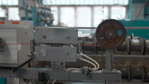 Rotating reels with copper wires on them. Creative. Metal wire spool spinning on the machine
