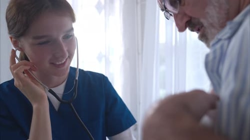Smiling young adult nurse examines senior patient