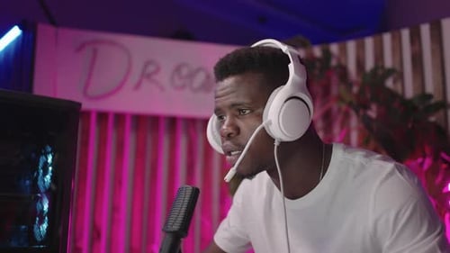 Young Adult Speaking into Microphone in Gaming Setup
