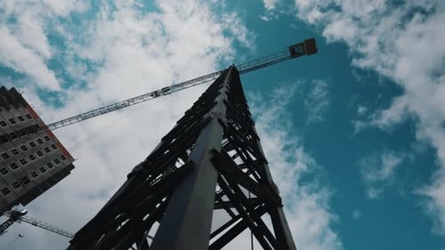 Tower Crane Mast and Jib Against Cloudy Sky From Low Angle View