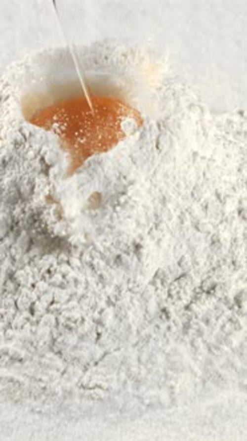 The Super Slow Motion of the Fresh Egg Falls Into the Pile of Flour Filmed on a Highspeed Camera at