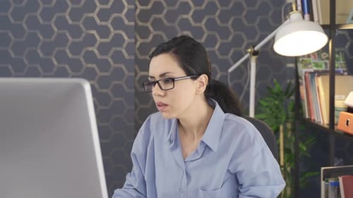 Young woman,confident manager or designer, sitting in front of computer monitor in her Office.